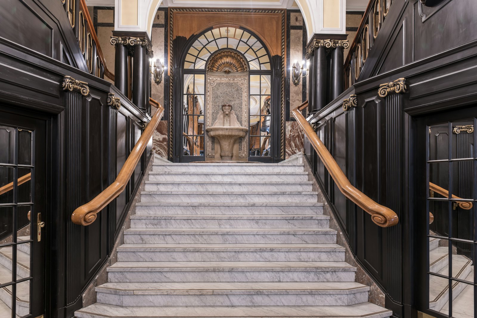 A marble staircase framed by dark panelled walls