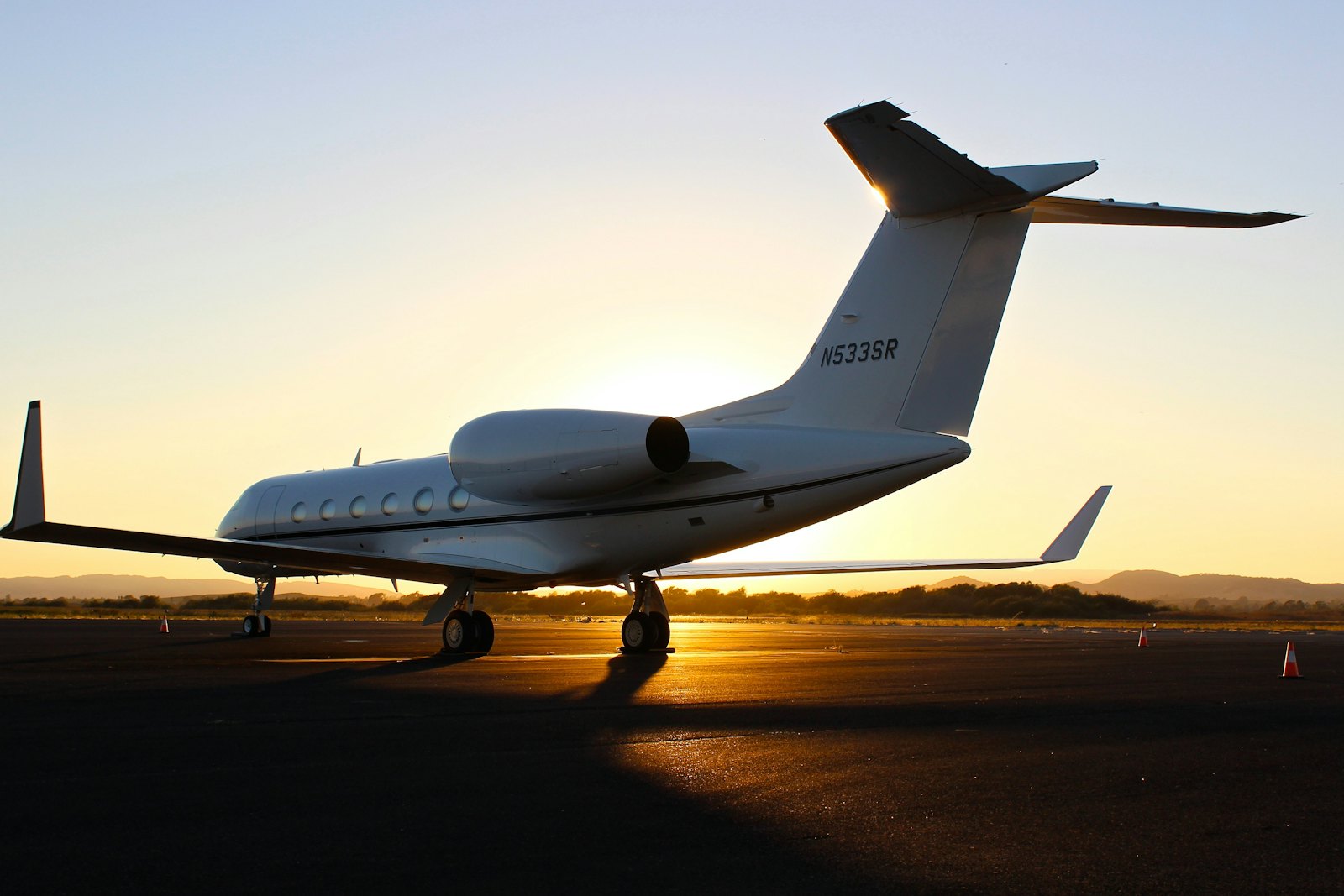 A private jet on the apron silhouetted against a low sun